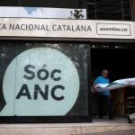 Dos voluntario trasladan la cartelería de la sede de la ANC