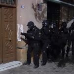 Varios agentes proceden a entrar en una de las viviendas registradas