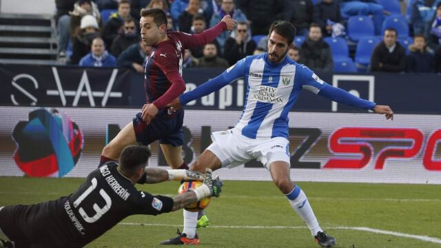 El portero del Leganés, Iago Herrerín, para un balón ante su compañero, el defensa Pablo Insua, y el centrocampista del Eibar Rubén Peña