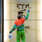 Un trabajador de limpieza borra la pintada de «gracias, ETA» en una calle de Bilbao