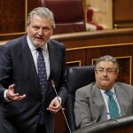 El ministro de Educación, Íñigo Méndez de Vigo (i), junto al ministro del Interior, Juan Ignacio Zoido (d), durante una de sus intervenciones esta tarde en el pleno del Congreso de los Diputados