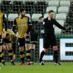 Un árbitro escucha las indicaciones de los jueces del videoarbitraje en la Premier League