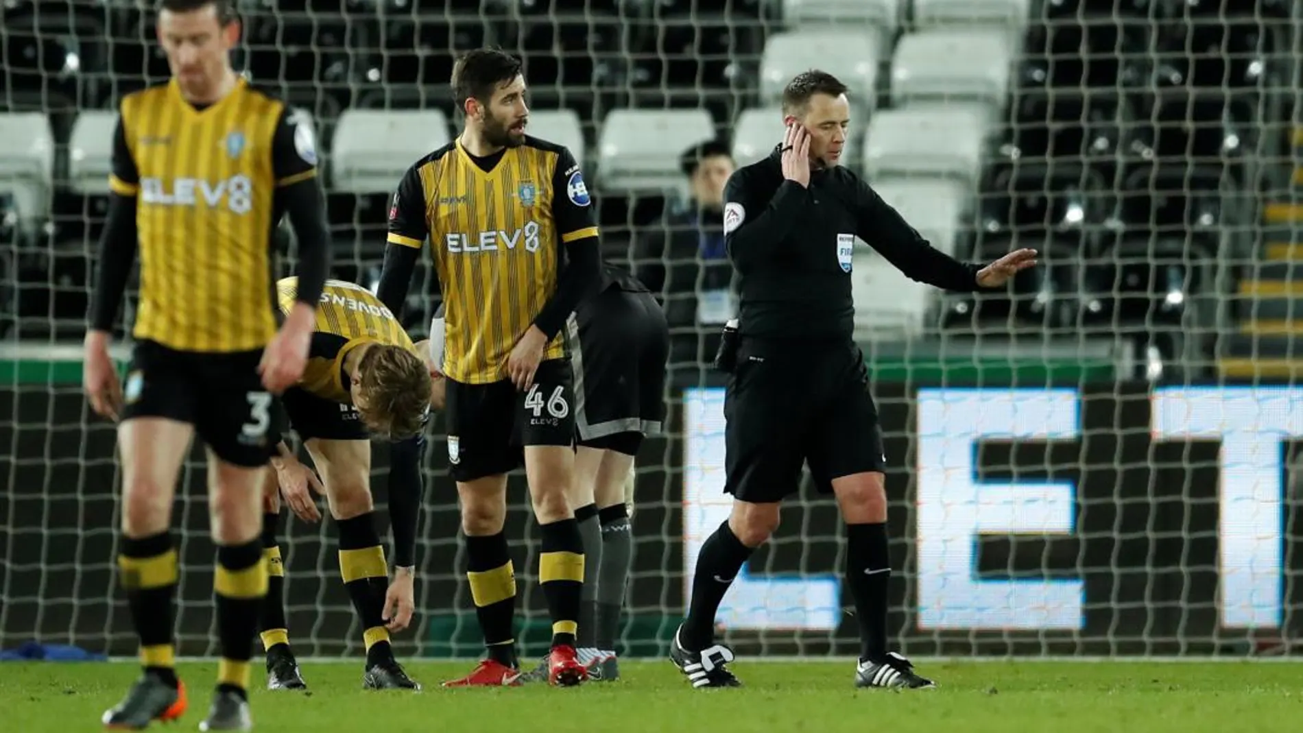 Un árbitro escucha las indicaciones de los jueces del videoarbitraje en la Premier League