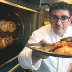 Eugeni de Diego en A Pluma mientras ultima varios pollos asados en el Josper de carbón, que llegan a la mesa con una guarnición de patata asada