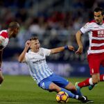 El centrocampista del Málaga CF Javier Ontiveros (2i) cae ante los jugadores del Granada CF, el defensa brasileño Gabriel Silva (i), el defensa francés Matthieu Saunier (2d) y el centrocampista Sergi Samper