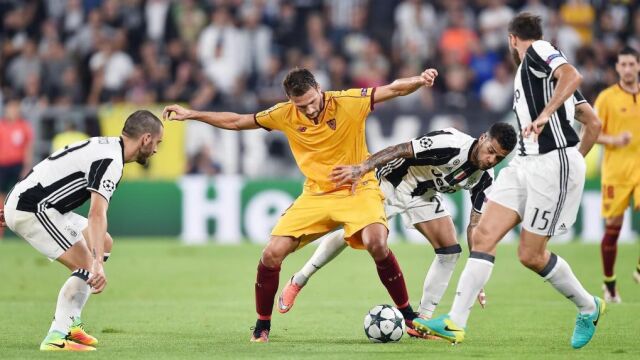 El jugador del Sevilla Franco Vazquez (ci) disputa el balón con Dani Alves (cd) del Juventus