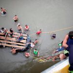 Un hombre sube a un puente con un niño en brazos en la frontera con México/Foto: reuters