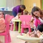 Milagros Marcos juega con un bebé durante su visita a l centro infantil «El Parque», en la localidad segoviana de Abades