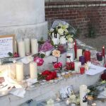 Vecinos de Saint-Etienne-du-Rouvray depositan velas ante el ayuntamiento de la ciudad. En la foto pequeña, Adel Kermiche, uno de los presuntos terroristas.