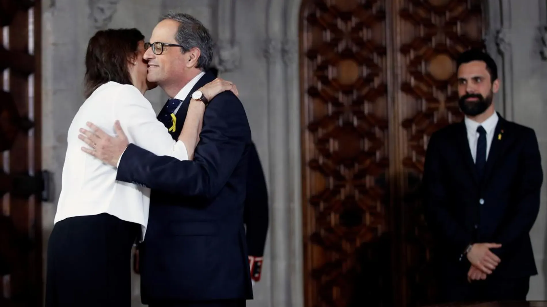 Quim Torra (c) saluda a su esposa, Carola Miró (i), ante el presidente del Parlament, Roger Torrent (d), tras tomar posesión de su cargo como presidente de la Generalitat / Efe