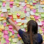 Una mujer deja una nota con un mensaje de apoyo en Las Ramblas de Barcelona, que poco a poco vuelven a la normalidad