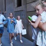 Hombres, mujeres y niños se alejan de la zona del atentado en Las Ramblas de Barcelona, ayer