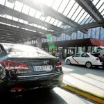 Un coche VTC, estacionado frente a un taxi en la zona de salidas de la estación de Atocha de Madrid / Foto: Rubén Mondelo