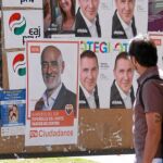 Un ciudadano observa ayer en Bilbao los carteles de la campaña a las elecciones autonómicas
