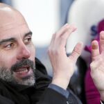 Pep Guardiola explica una jugada a uno de sus ayudantes en el banquillo