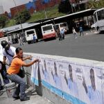 Seguidores de Héctor Rodriguez pegan carteles electorales en el estado de Miranda donde era gobernador Henrique Capriles