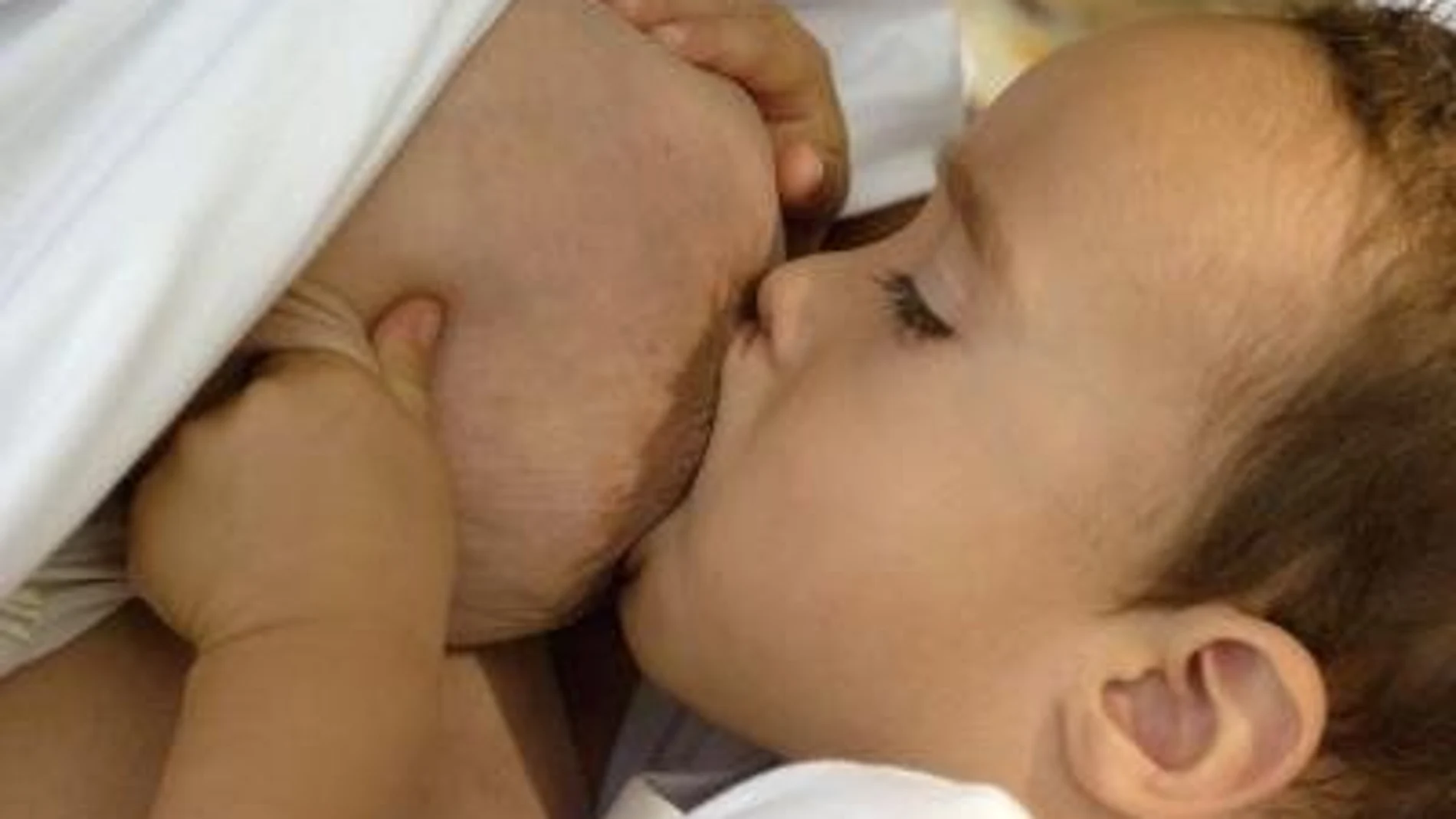 Una madre embarazada dando el pecho a su hijo de dos años