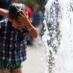 Un niño se refresca el pasado 14 de diciembre en las calles de Santiago (Chile), durante días de temperaturas extremas.