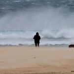 Una mujer pasea junto a su perro ayer lunes en la playa de los Lances en Tarifa (Cádiz).