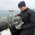 Un integrante del servicio de emergencias ruso inspecciona uno de los restos del fuselaje rescatado del mar Negro