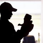 Imagen de archivo de un hombre sosteniendo a su hija con microcefalia en Brasil