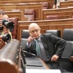 El presidente, Mariano Rajoy, y la vicepresidenta, Sáenz de Santamaría, escuchan al ministro de Hacienda, Cristóbal Montoro