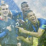Pogba, Griezmann y Mbappé celebran el triunfo señalando el gallo del escudo
