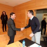 El consejero de Empleo, Carlos Fernández Carriedo, saluda al procurador socialista Pedro González, antes de comparecer en las Cortes