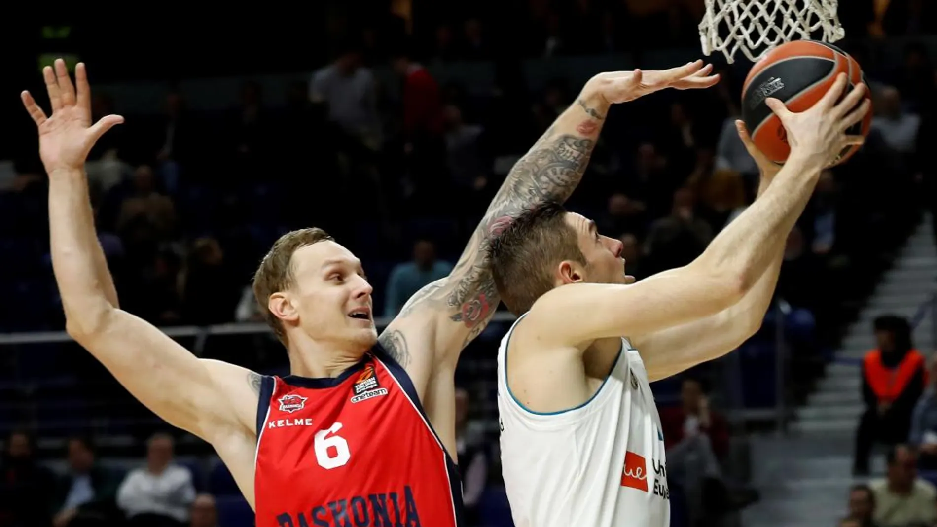 El escolta del Baskonia Janis Timma (i) hace un tapón al escolta francés del Real Madrid, Fabien Causeur durante el partido correspondiente a la jornada 18 de la fase regular de la Euroliga