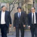 Carles Puigdemont junto a Oriol Junqueras y el conseller de la Presidencia, Jordi Turull (d), se dirigen hoy a la reunión semanal del Govern.