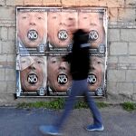Un transeúnte pasa en Roma junto a un cartel a favor del «no» en el referéndum constitucional de este domingo
