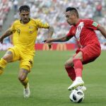 El australiano Joshua Risdon lucha por robarle el balón al mediocentro peruano Christian Cueva / Ap