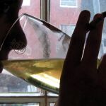Un cliente de un bar con un cigarro y bebiendo alcohol, en una imagen de archivo