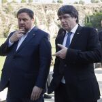 El presidente de la Generalitat, Carles Puigdemont (d), conversa con el vicepresidente Oriol Junqueras (i), tras asistir a la tradicional ofrenda ante la tumba del presidente de la Generalitat republicana Lluís Companys