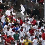 Dos toros de la ganadería de Núñez del Cuvillo entran en la curva de Mercaderes durante el séptimo encierro de los sanfermines 2016