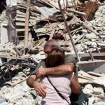 Dos lugareños se abrazan ante varias casas derrumbadas en Pescara del Tronto, cerca de la localidad de Arquata del Tronto.