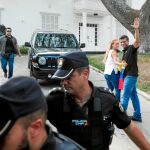 Leopoldo López y su esposa, Lilian Tintori, custodiados por la Policía Nacional, tras su declaración ayer a la entrada de la residencia del embajador español en Caracas / Efe