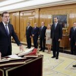 El reelegido presidente del Gobierno, Mariano Rajoy (i), jura el cargo ante el Rey.