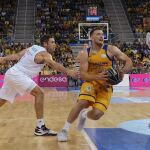 El base israelí del Herbalife Gran Canaria Gal Mekel (c) entra a canasta entre el estadounidense Anthony Randolph (d) y el francés Fabien Causeur (i), del Real Madrid