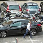 Un vehículo de alquiler con conductor recoge a un cliente en un calle de Madrid