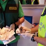 Dos agentes hacen recuento del dinero incautado