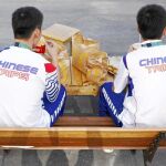 Dos atletas chinos comiendo hamburguesas en la Villa Olímpica