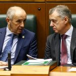 El lehendakari, Iñigo Urkullu (d), y el consejero de Gobernanza Pública y Autogobierno, Josu Erkoreka, conversan durante el pleno del Parlamento Vasco. EFE
