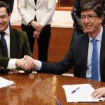 Juanma Moreno y Juan Marín estrechan las manos durante la reunión que han tenido esta tarde en el Parlamento de Andalucía para sellar su acuerdo de gobierno. EFE/Jose Manuel Vidal.