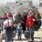 Civiles sirios cargan con sus pertenencias antes de ser evacuados ayer de la provincia de Guta Oriental con destino a Idlib