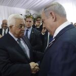 El primer ministro israelí, Benjamin Netanyahu, saluda al presidente palestino, Mahmud Abás