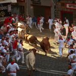Los toros de la ganadería gaditana de Cebada Gago al final de la cuesta de Santo Domingo durante el tercer encierro de los Sanfermines 2018.