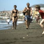 Imagen de archivo de una pareja que pasea por la playa malagueña del Rincón de la Victoria ante el buen tiempo en la Costa del Sol