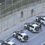 Varios vehículos de la Guardia Civil protegían ayer la frontera de Ceuta, que Interior reforzará con 19 agentes más tras la avalancha de esta semana