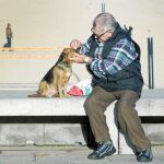 Un hombre cuida de su perro en la playa de la Barceloneta. Foto: Shooting